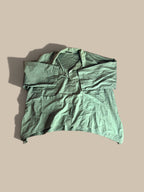 Eleven Stitch Design sage green asymmetrical snap-front pocket shacket front flat lay with sleeves folded