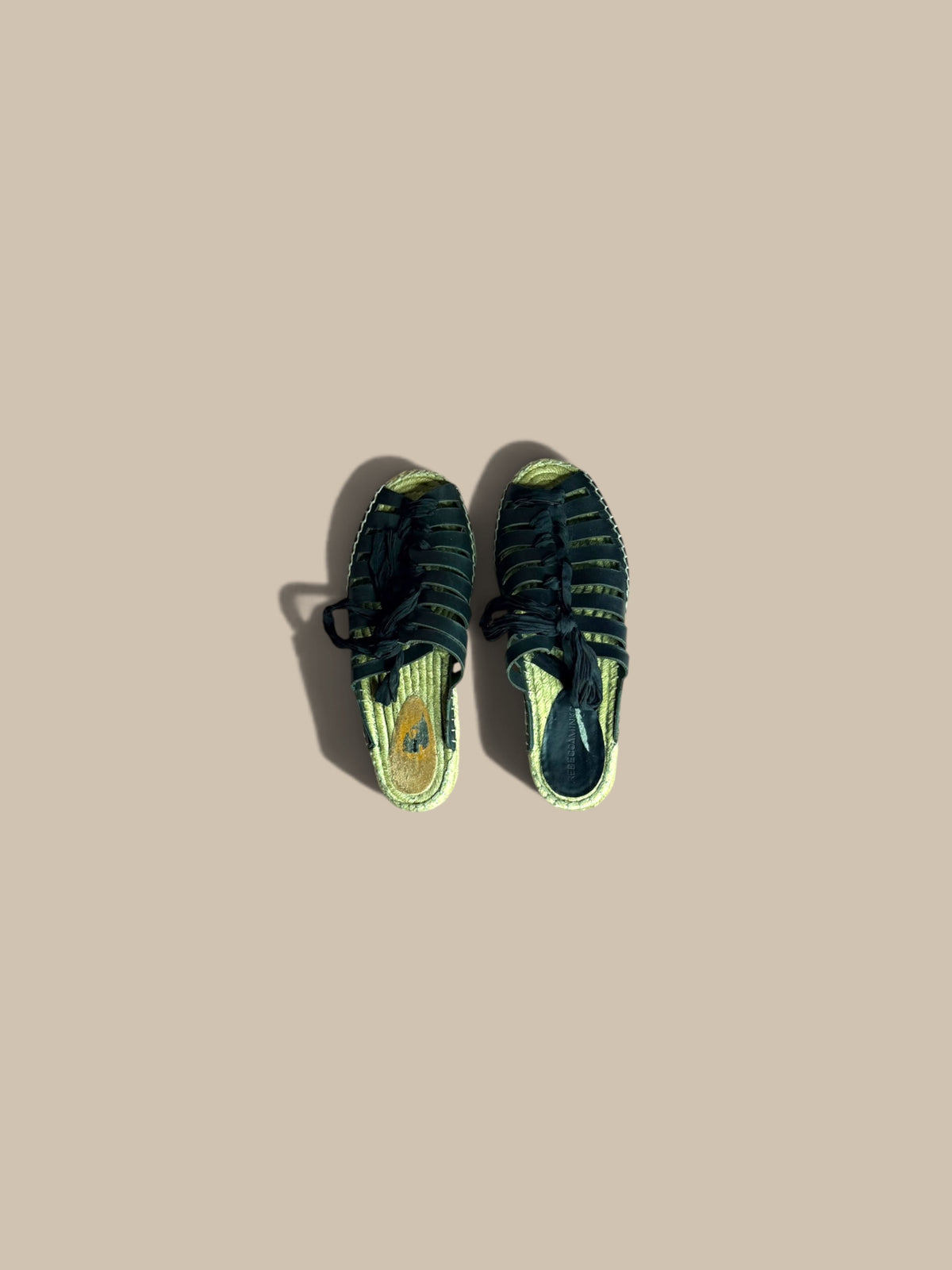 A pair of Free People Gable black gladiator espadrille slide sandals shown from a top-down view on a solid beige background.