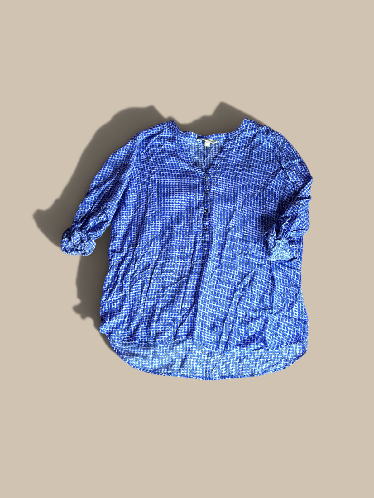 Grand & Greene royal blue and off-white geometric print high-low blouse shown in a front flat lay with right sleeve bent