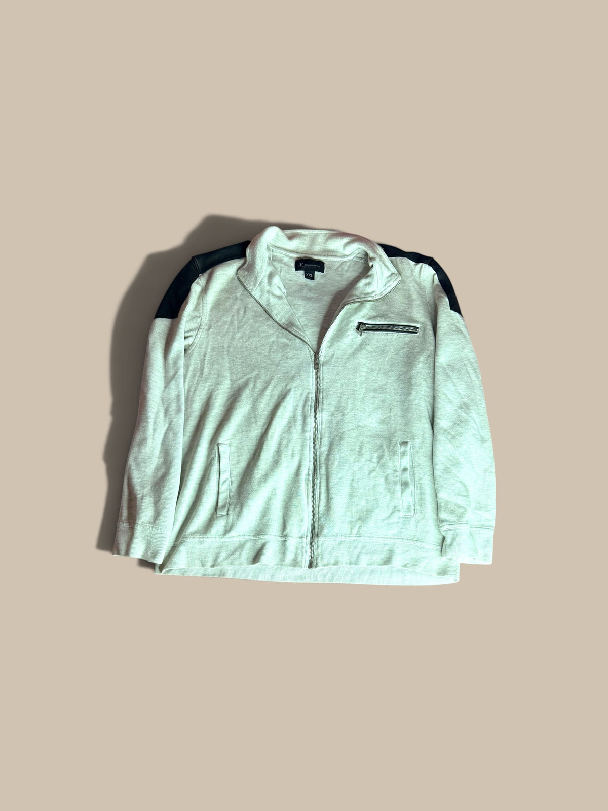 An I.N.C. International Concepts light gray heather full-zip knit jacket, laid flat on a solid beige background. 