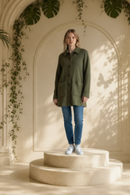 Woman stand on a pedestal wearing Joan Vass vintage herringbone knit jacket pointed collar and four-button front, denims jeans, and white sneakers.