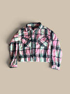 A Jolie & Joy plaid cropped shirt jacket with folded sleeve detail in pink and black, laid flat against a solid beige background.