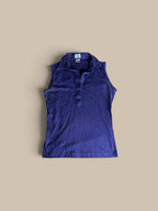 A Leon Levin deep purple indigo sleeveless polo shirt, laid flat on a solid beige background.
