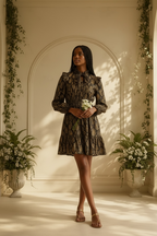 Model poses wearing a MICHAEL Michael Kors gold foil python print mini dress styled with a bouquet
