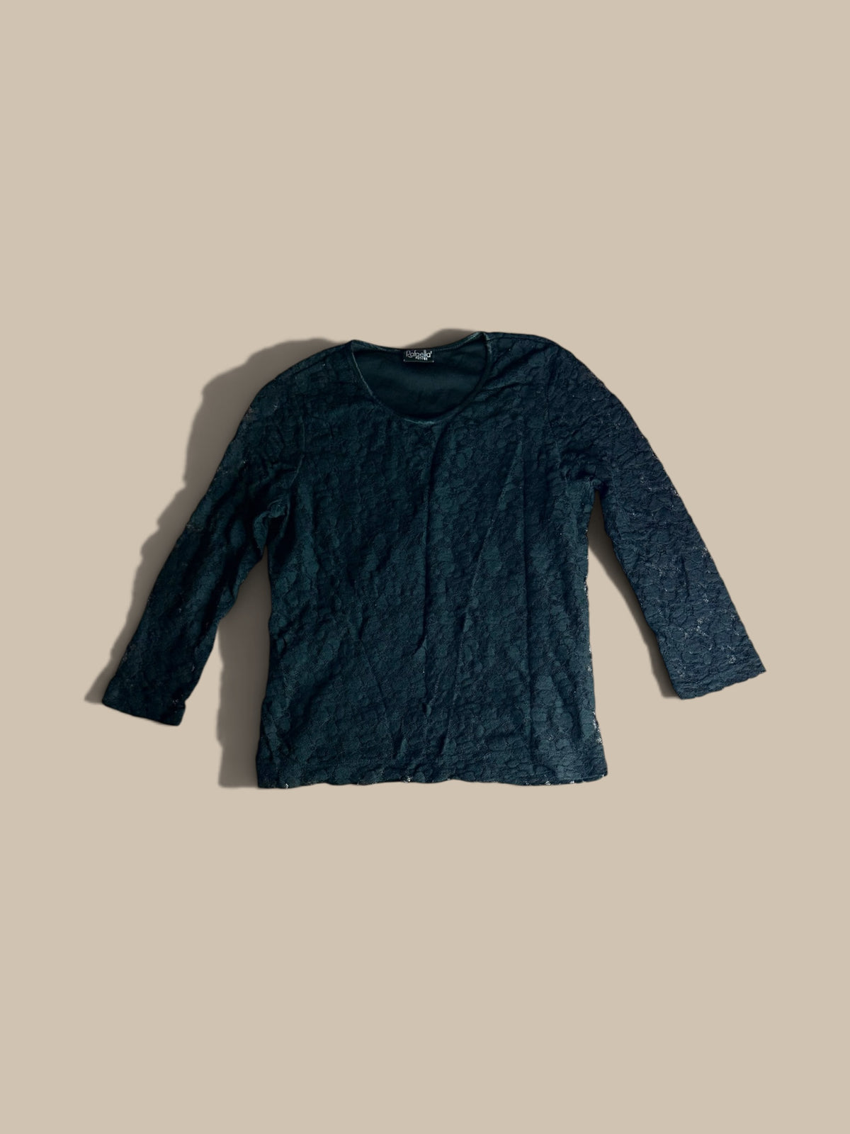 A Rafaella black floral lace petite top, laid flat on a solid beige background.