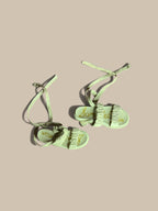 A pair of Sam Edelman Velma cream beige ruched espadrille sandals  with gold foil script lettering on the soles, displayed on a solid beige background.