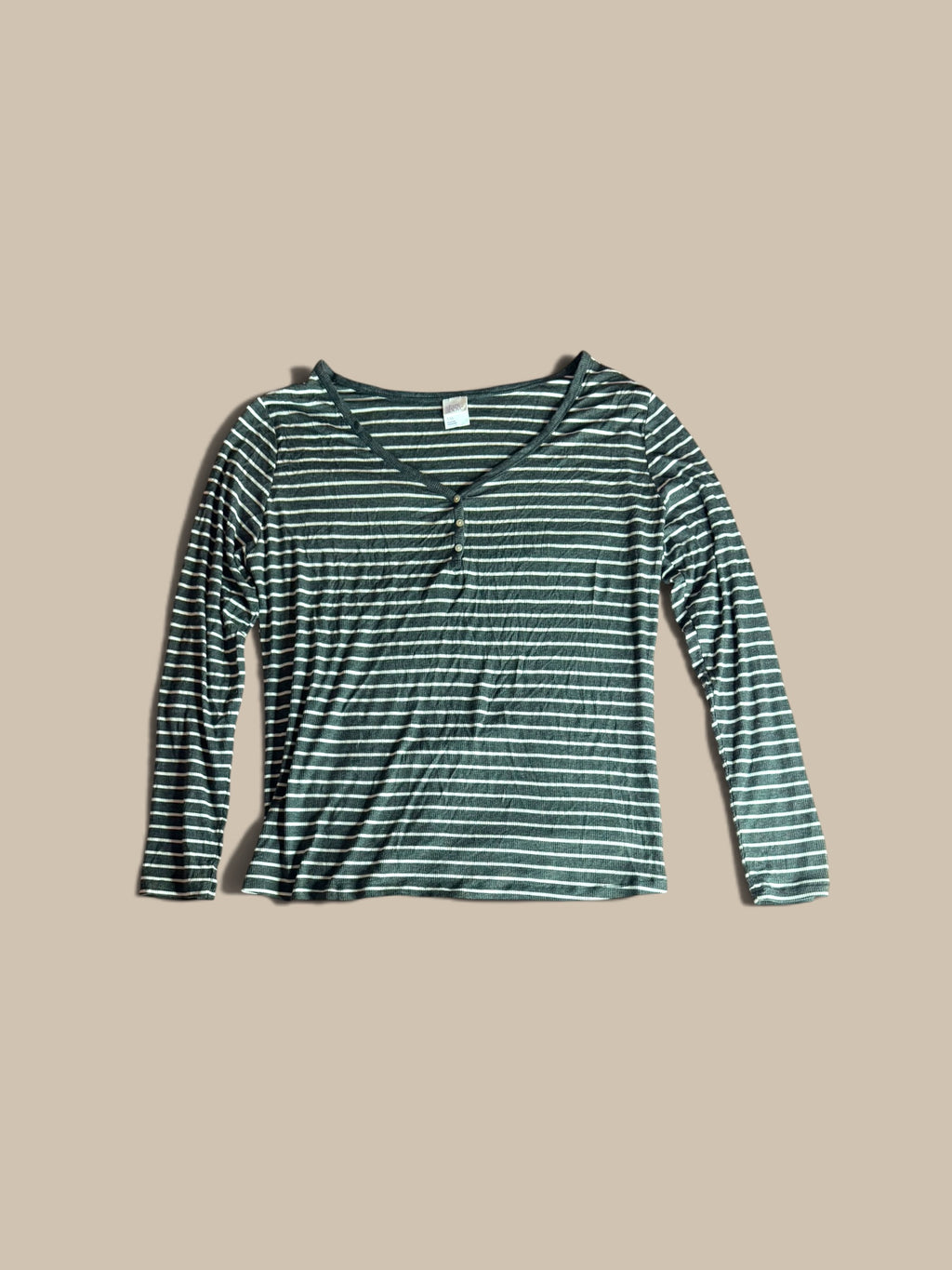 A long-sleeve V-neck Stars Above charcoal grey and white striped Henley pajama, featuring a small button placket at the neckline, laid flat against a solid beige background.