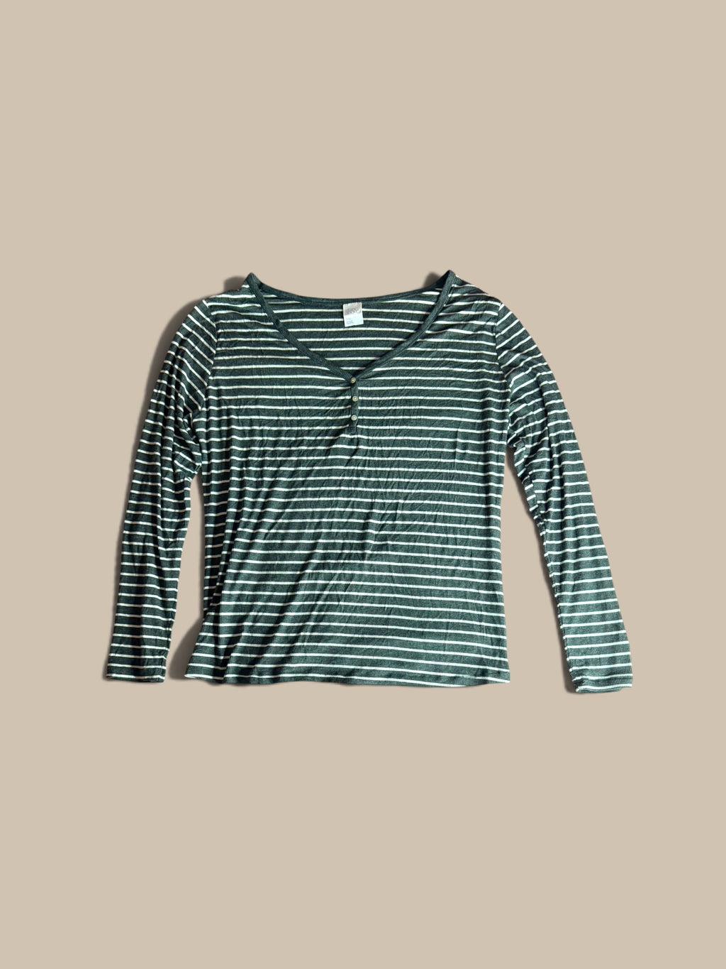 A long-sleeve Stars Above charcoal grey and white striped Henley pajama top, laid flat against a solid beige background.