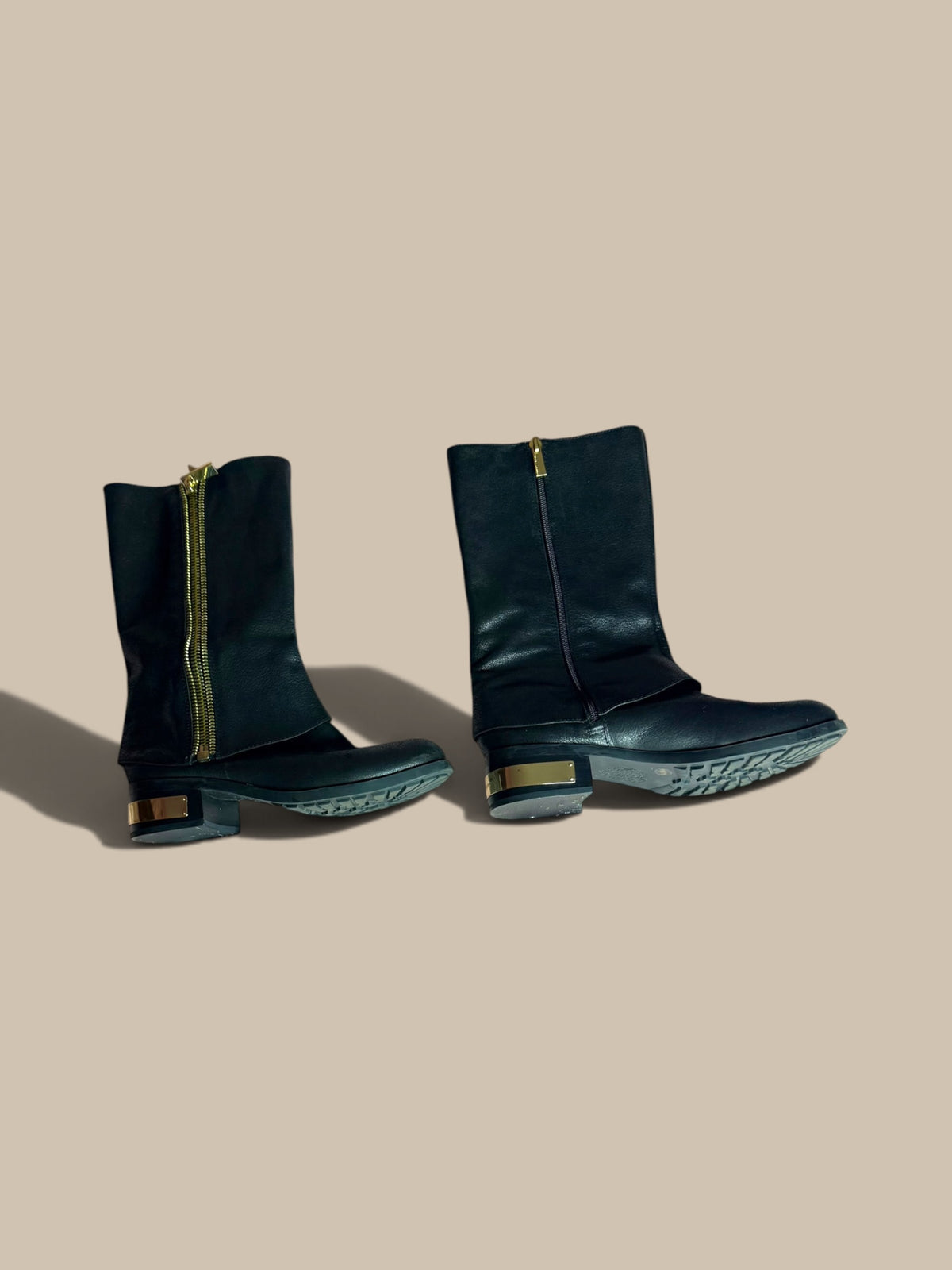 A pair of Camuto Winxie black leather fold-over moto boots showing multiple side views, displayed on a solid beige background.